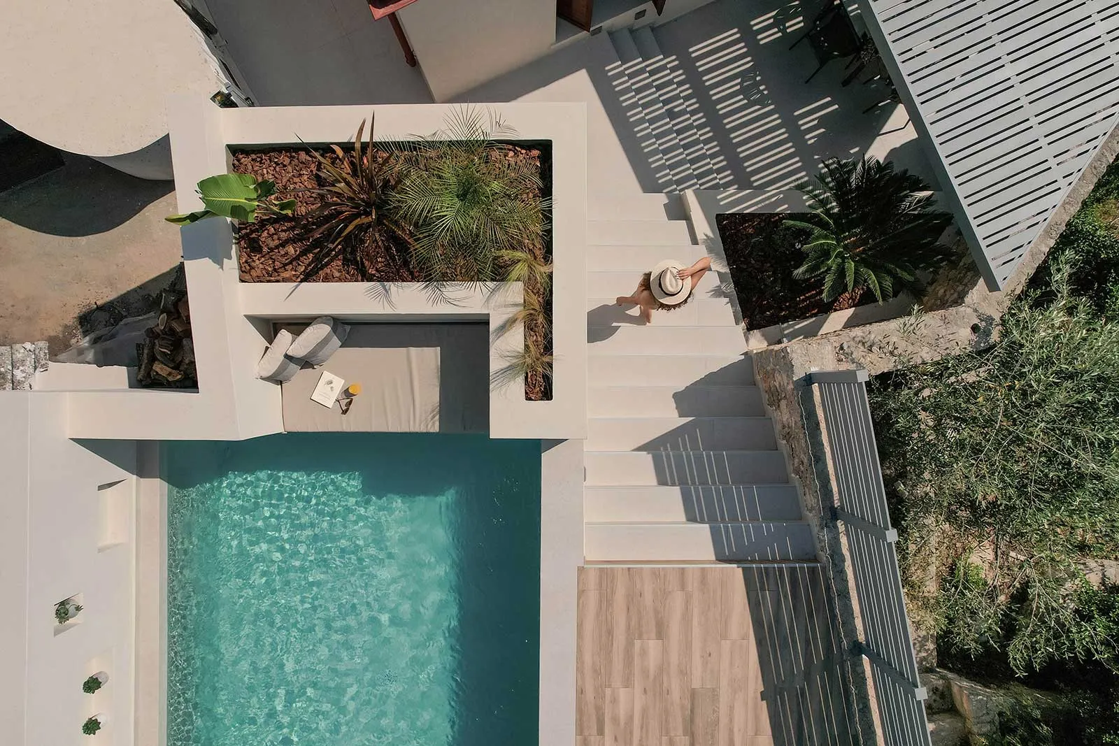 A minimalist residential pool with concrete finishes and stone accents.