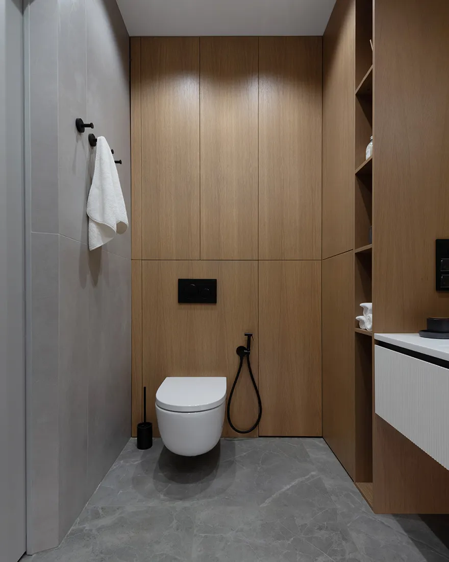 A modern bathroom with wooden panels and grey tiles.