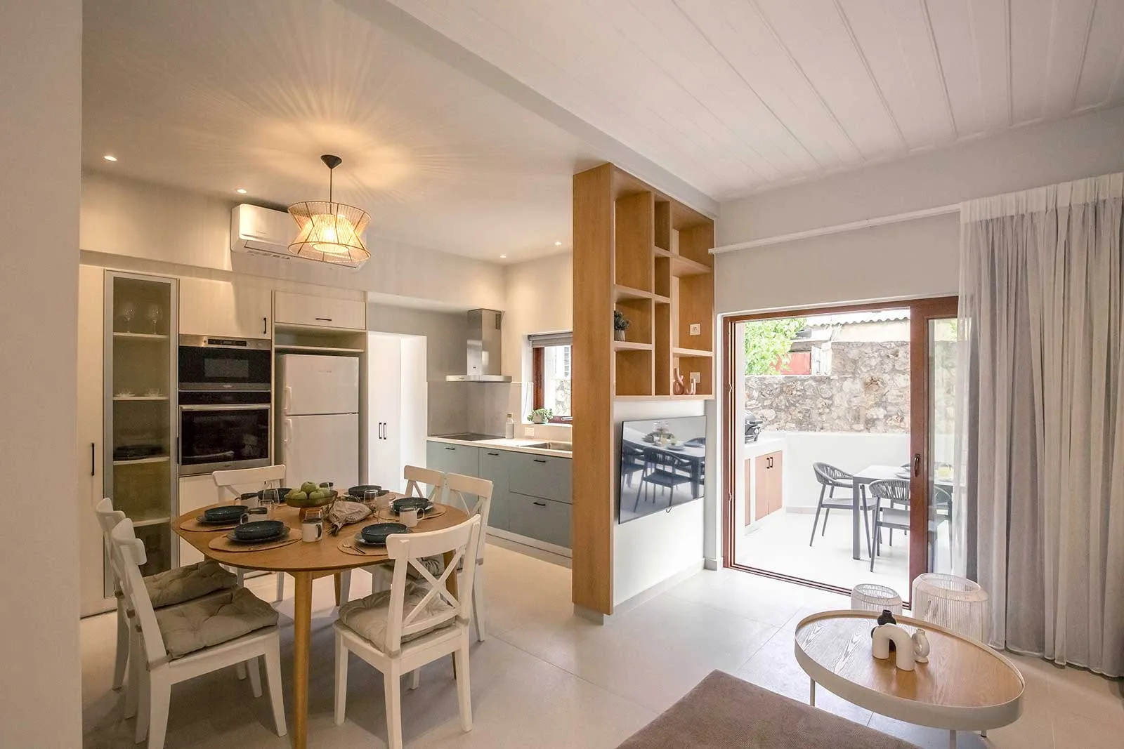 Modern minimalist kitchen with concrete countertops, wood composite flooring, and white cabinets.