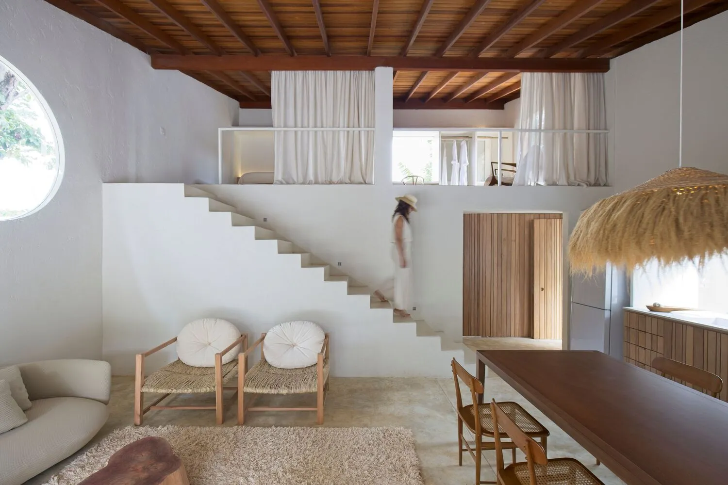 Modern minimalist residential interior with concrete staircase and white decor.