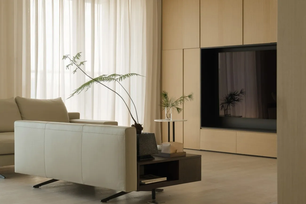 Minimalist modern living room designed with wooden panels and leather furniture.