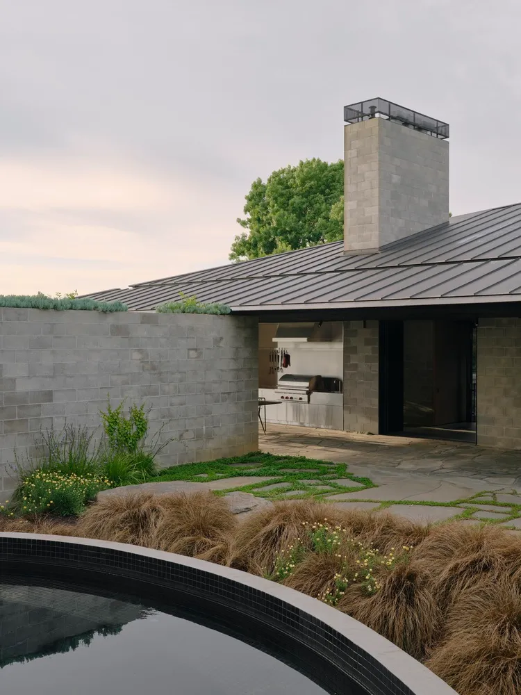 A modern residential exterior featuring concrete and metal materials with a glass window.