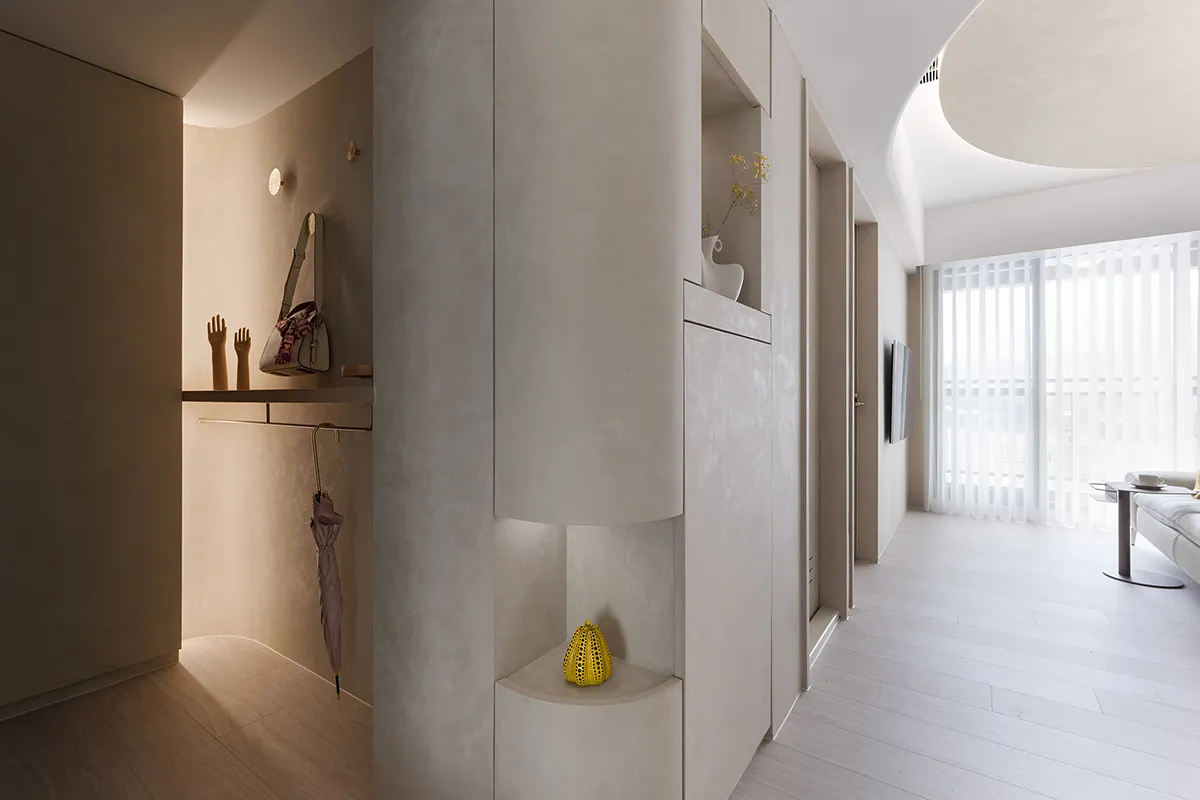 Minimalist apartment with modern ceramic walls, white wood flooring, and white curtains by day.