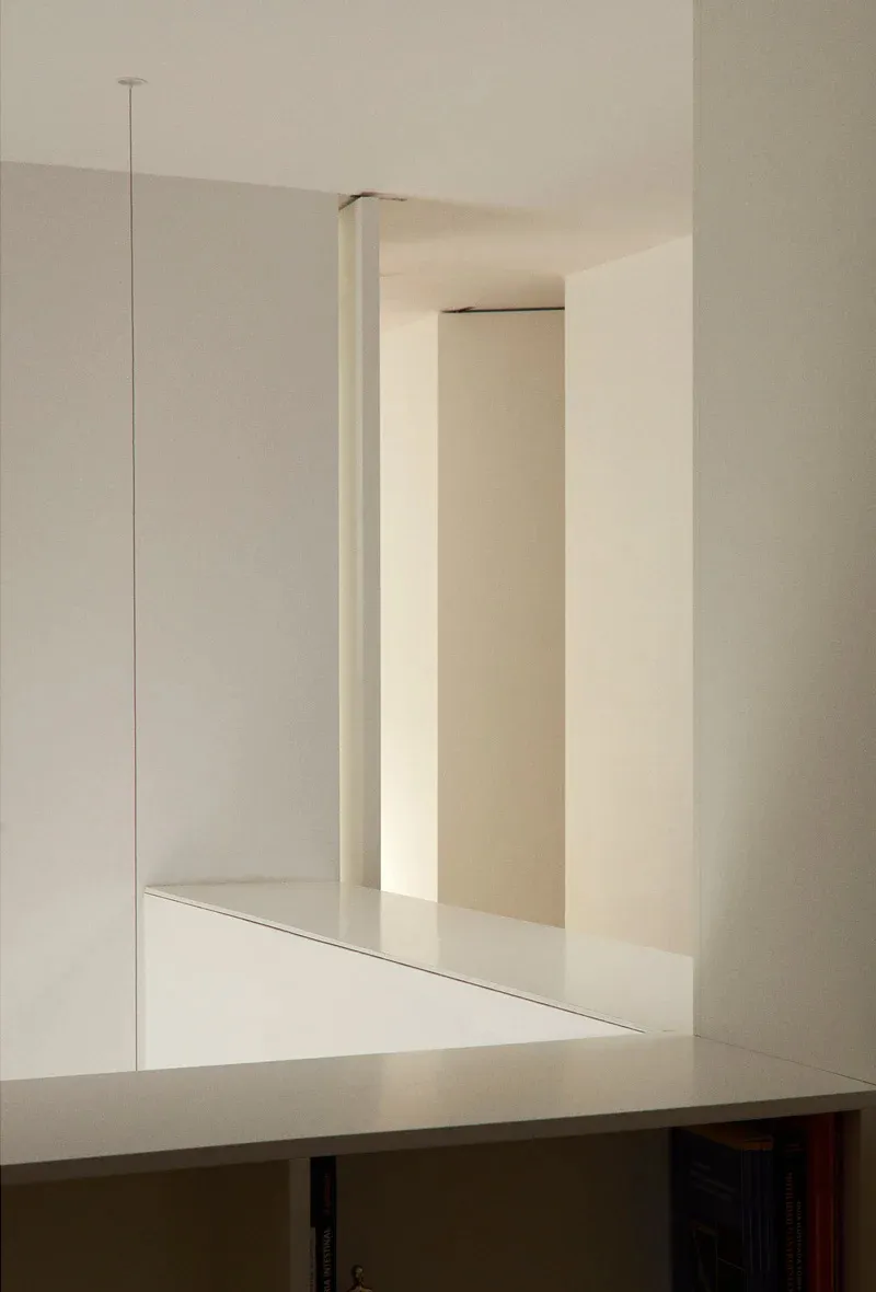 Interior design featuring a minimalist space with concrete walls and surfaces.