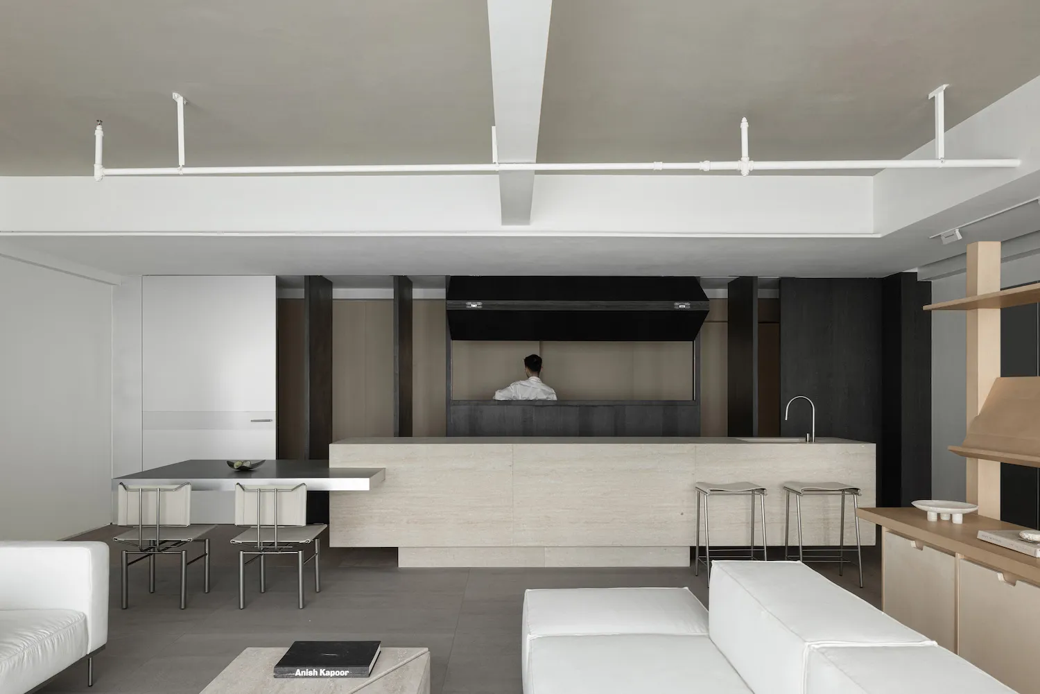 Modern, minimalist interior featuring a concrete bar and seating area.