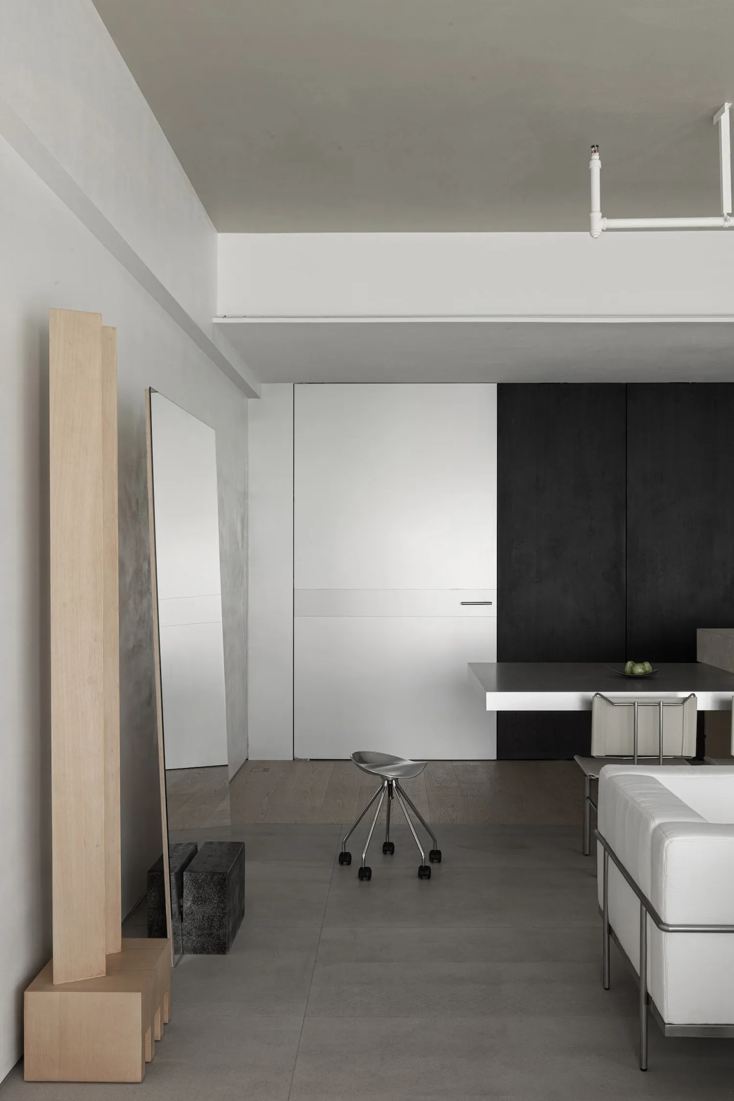 A minimalist living room with concrete surfaces and a modern chair.