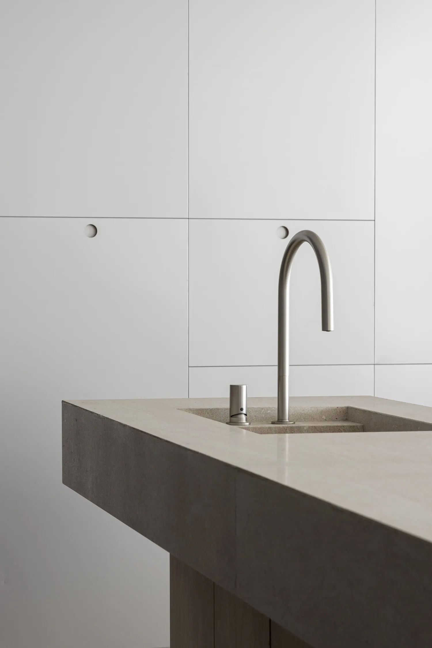 Modern bathroom featuring a concrete vessel sink and sleek faucet.