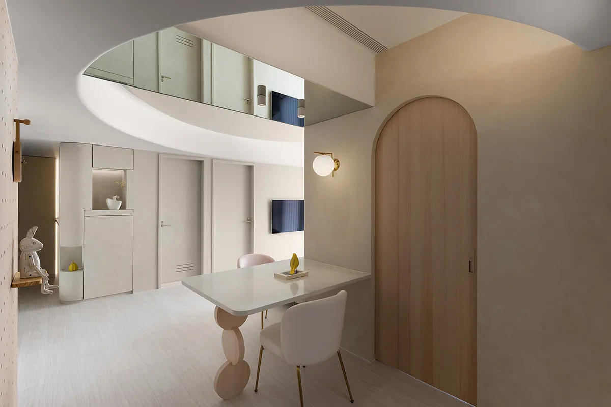A modern dining room featuring a white table and chairs, with minimalist design elements and a warm, inviting atmosphere.