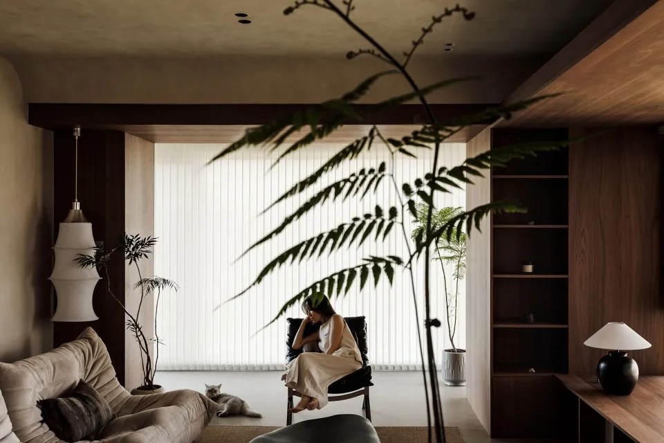 A modern living room featuring wooden elements, plants, and a cozy atmosphere.