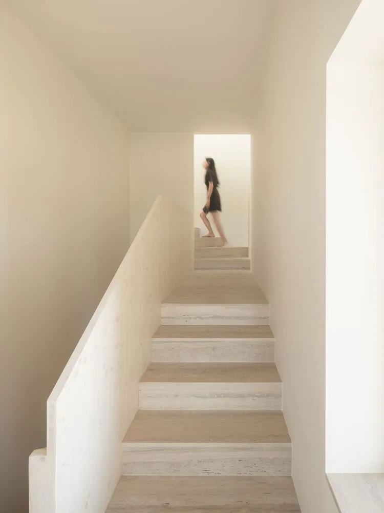 A modern staircase with marble steps and railings in a minimalist setting.