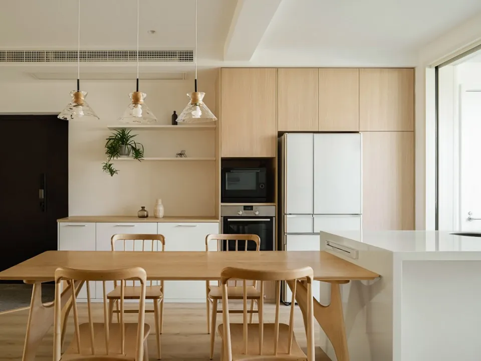 A modern minimalist residential kitchen featuring wooden furniture and white cabinets.