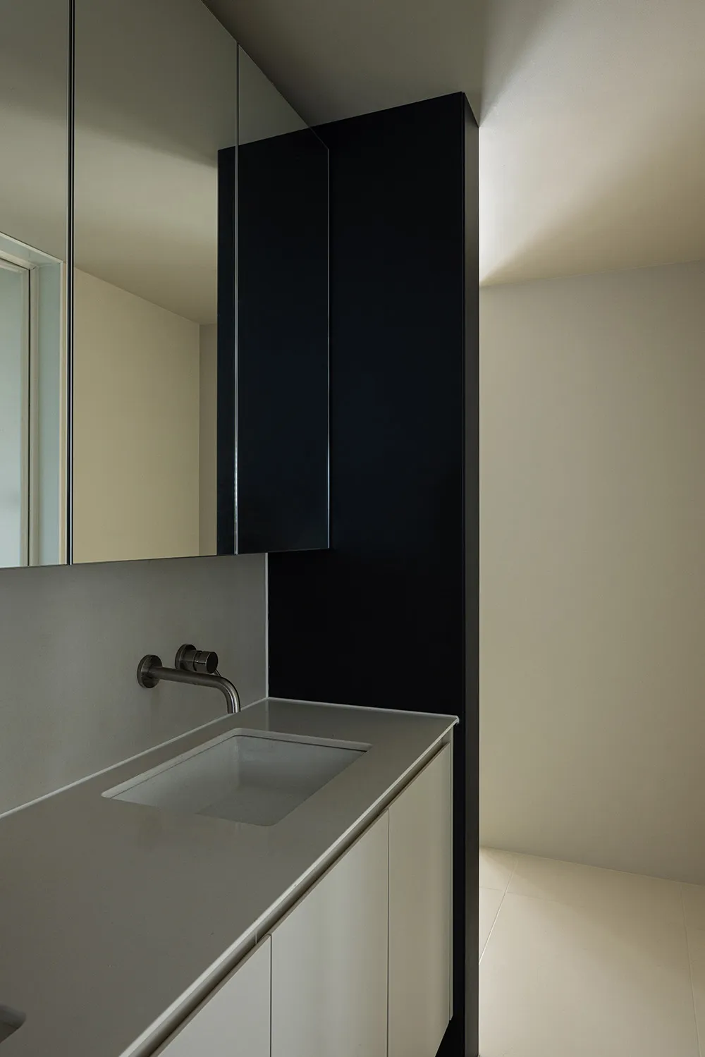 Modern bathroom with a minimalist design featuring ceramic tiles and black accents.