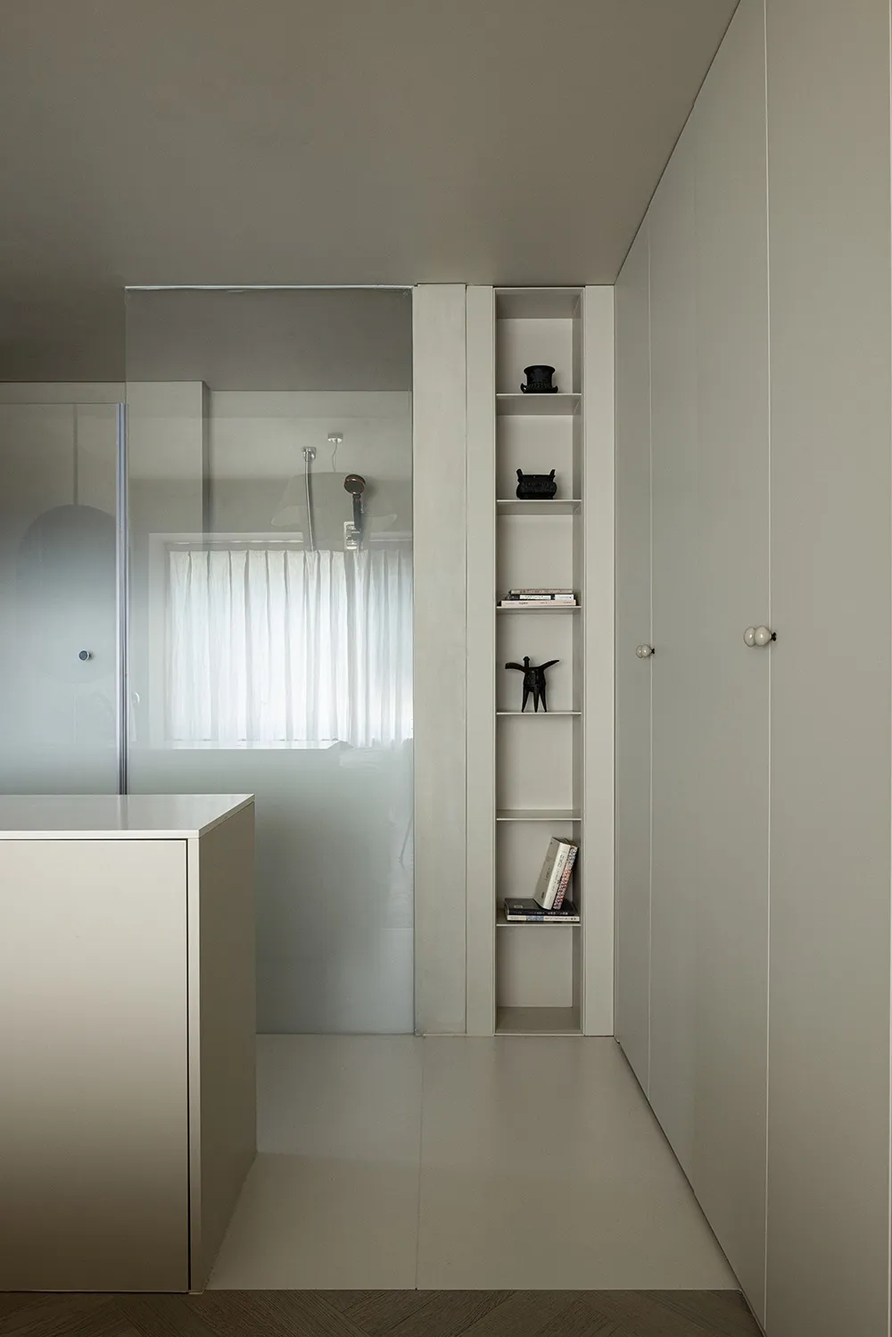 A minimalist modern bathroom with concrete shelving and a frosted glass wall.
