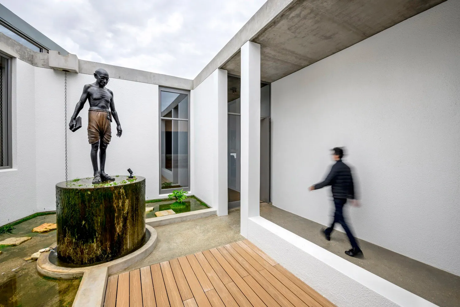 A modern interior space featuring concrete and wood materials and furniture.