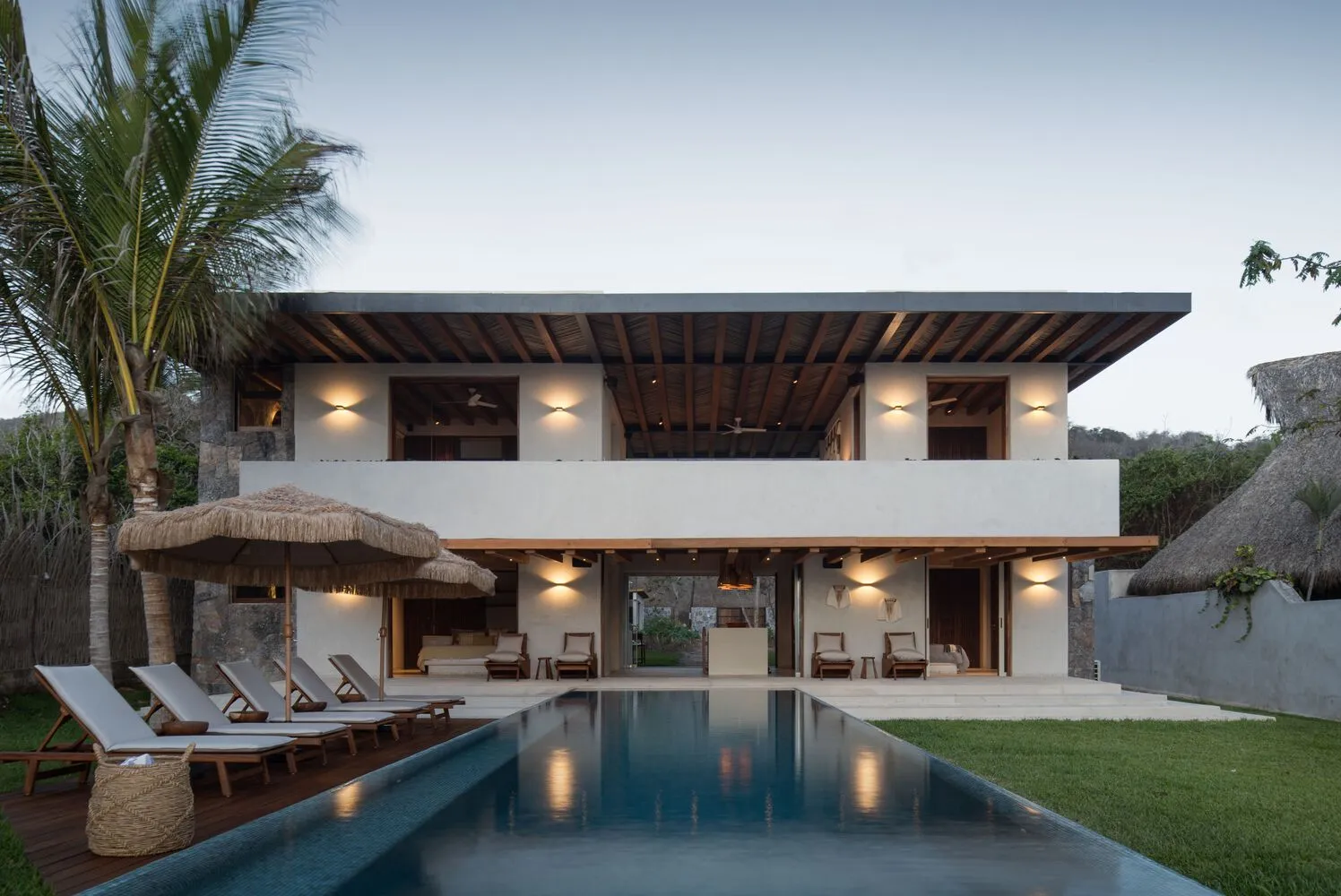 A luxurious villa with a pool, clay-tile roofing, and concrete accents.