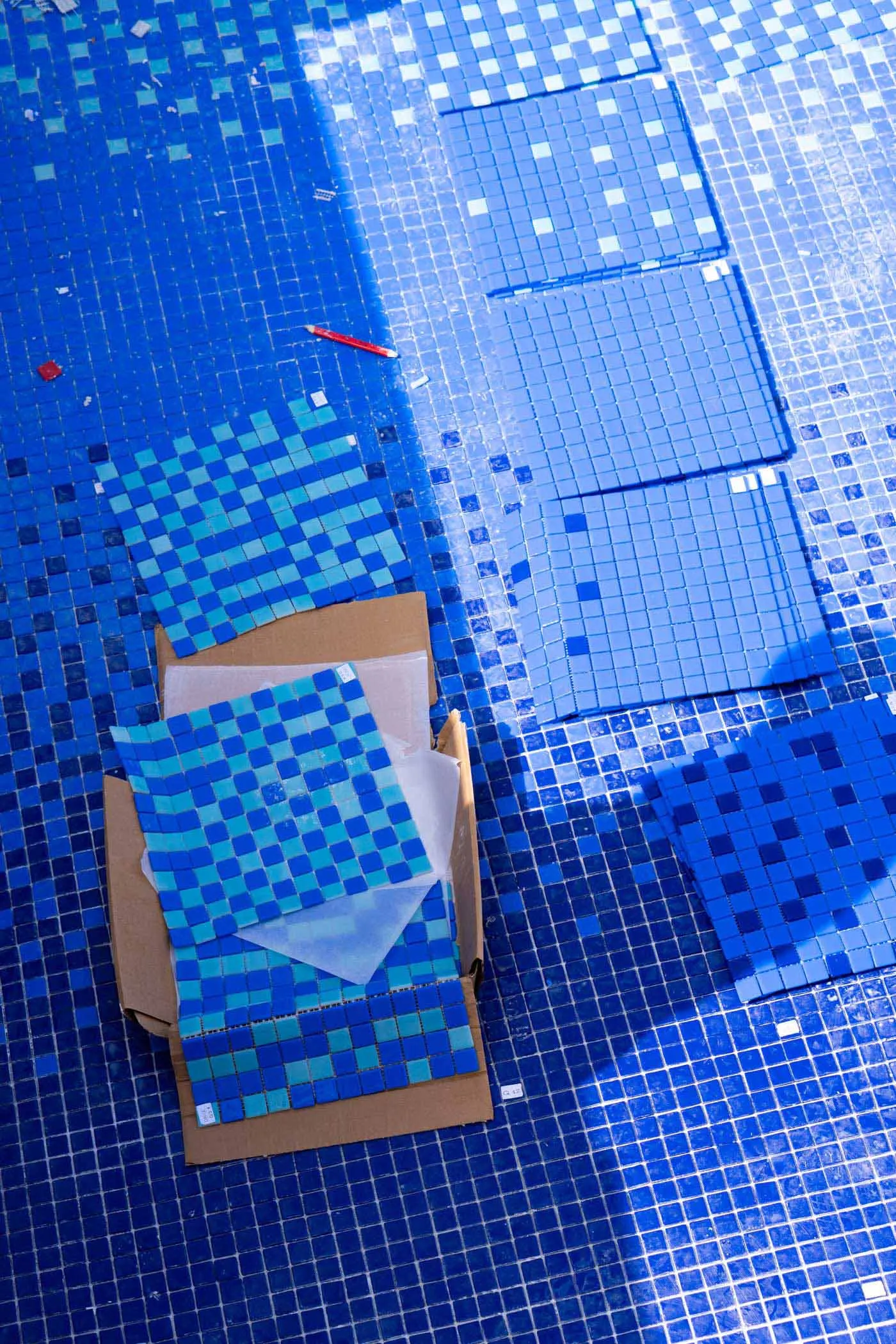 Blue floor tiles with different shades laid out in a pattern on a surface.