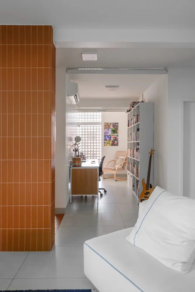 Contemporary living room featuring orange tiles and concrete flooring, minimalist design, and a cozy seating area.