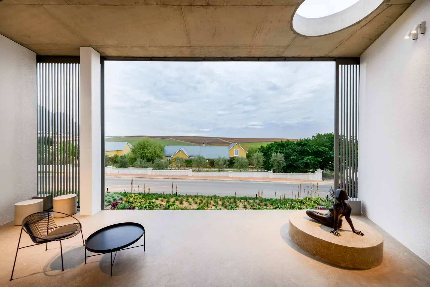 Minimalist residential interior with concrete, glass, and metal elements.