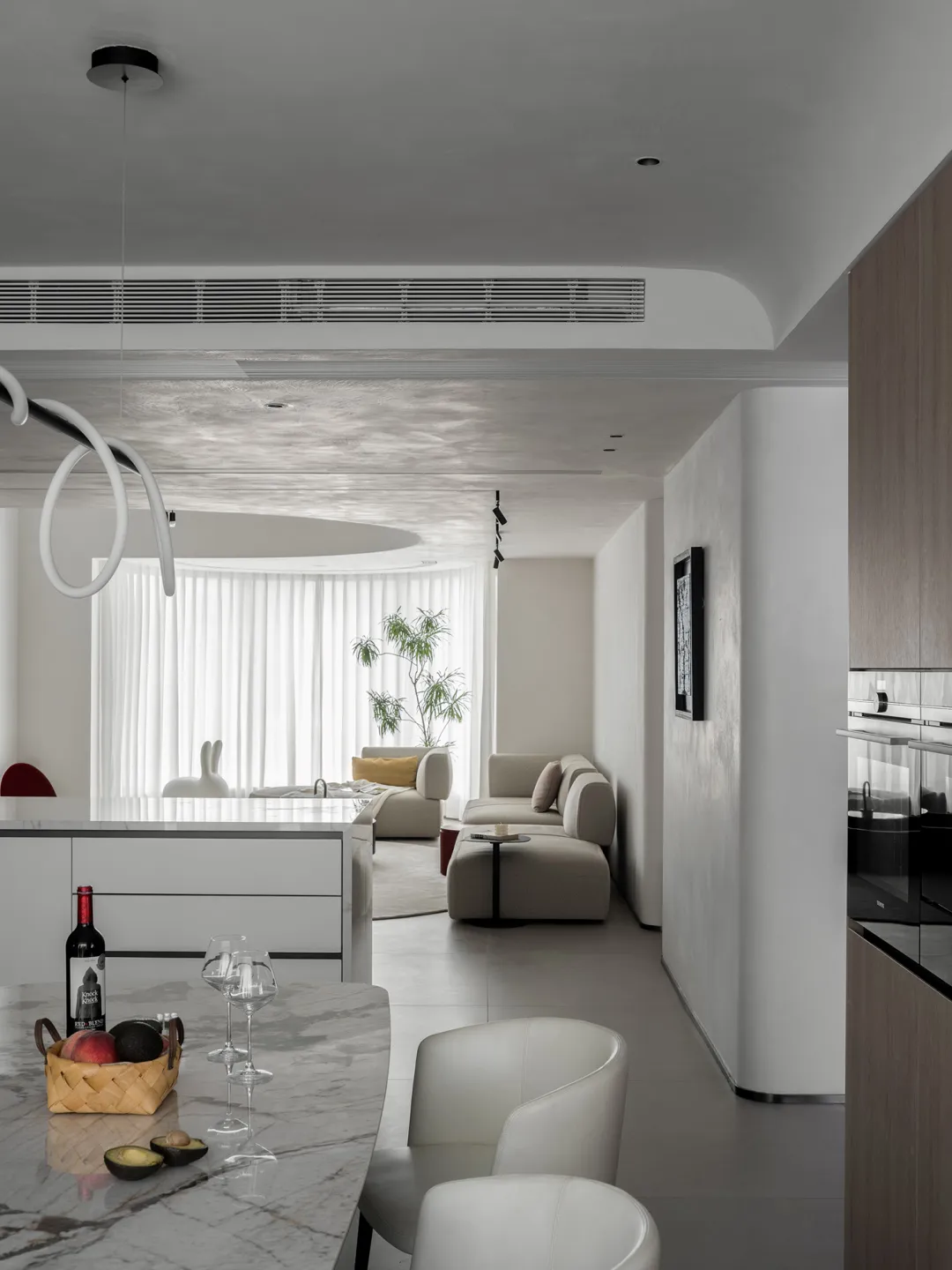 Modern residential interior with beige textiles and marble countertops.