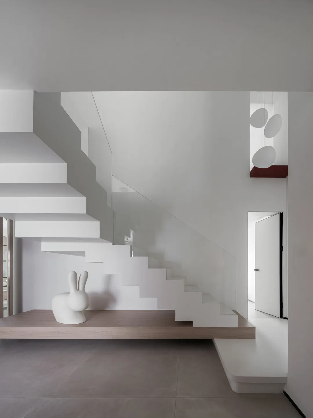 Modern minimalist interior featuring wood, concrete, and glass materials.