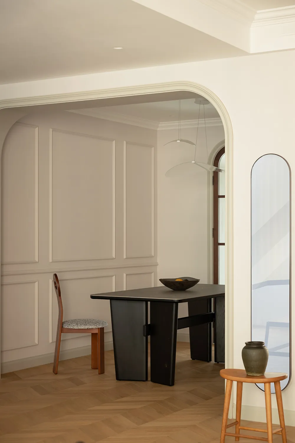 Modern interior design featuring a dining room with wood elements, including a table, chairs, and vase.