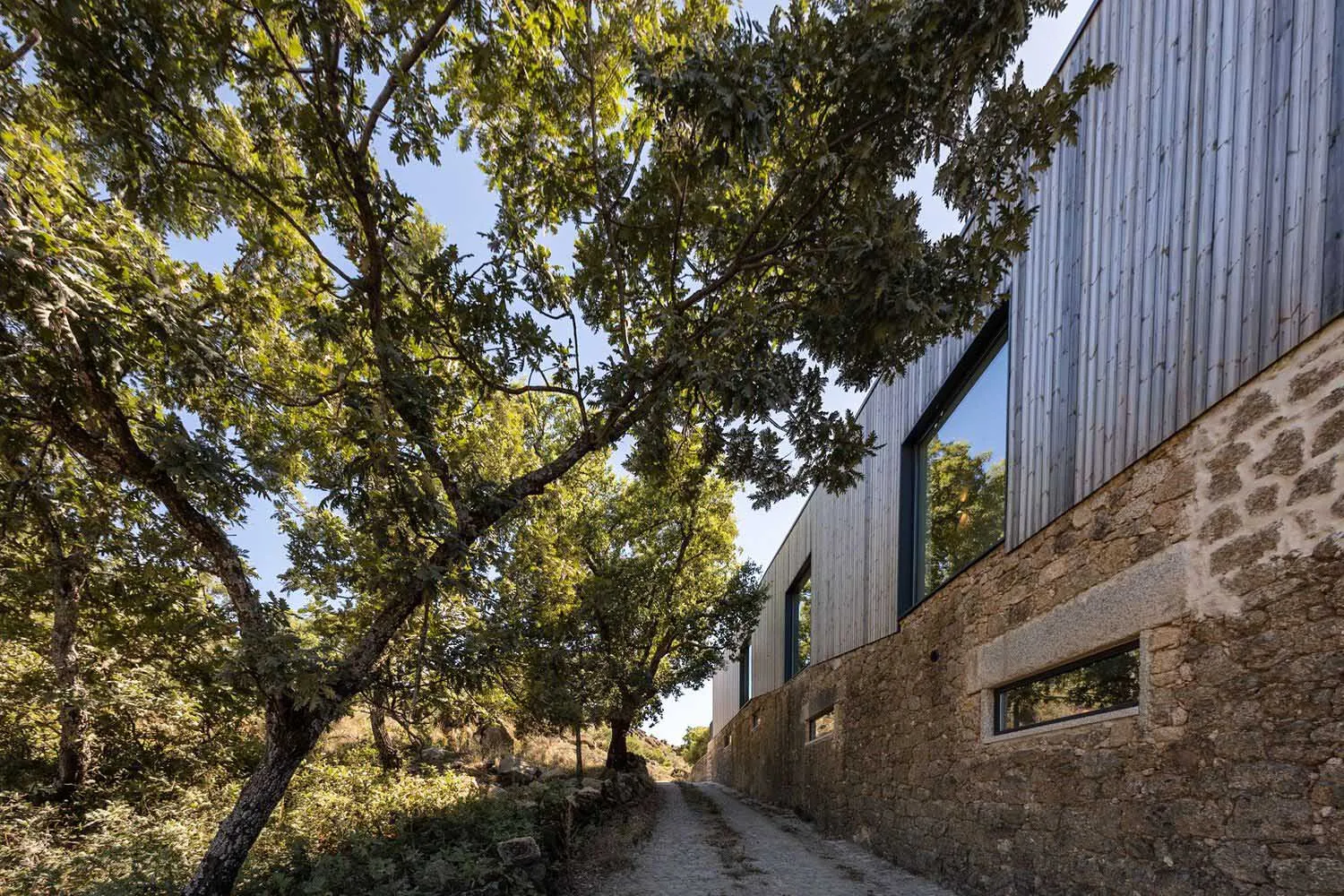 A modern residential building with a metal-clad exterior, surrounded by trees and natural surroundings.