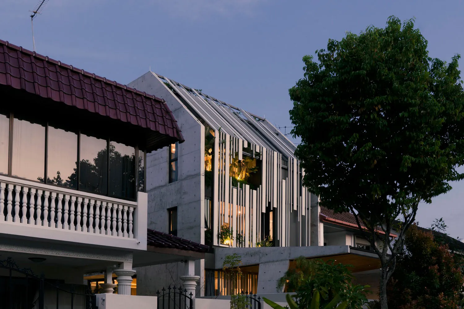 A modern residential house with a concrete facade and vertical slats.