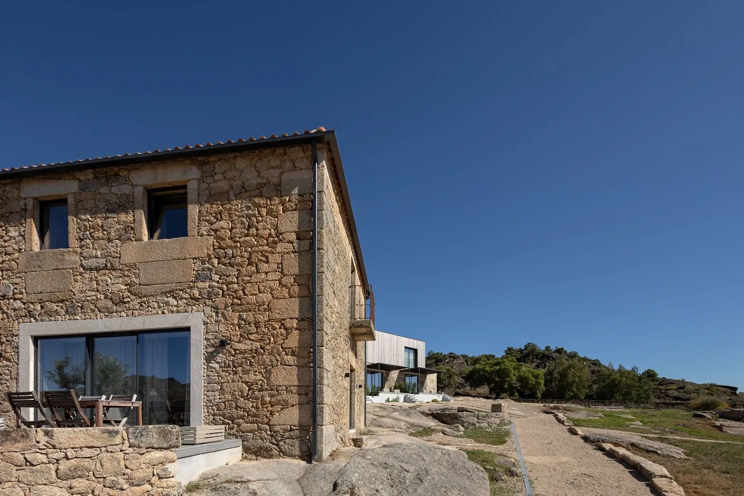 A residential house with a stone exterior in a countryside setting.