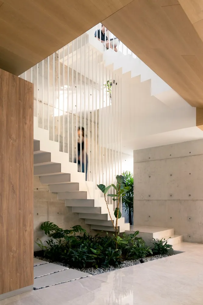 Modern, industrial-style staircase featuring concrete steps, glass railing, and timber finish.