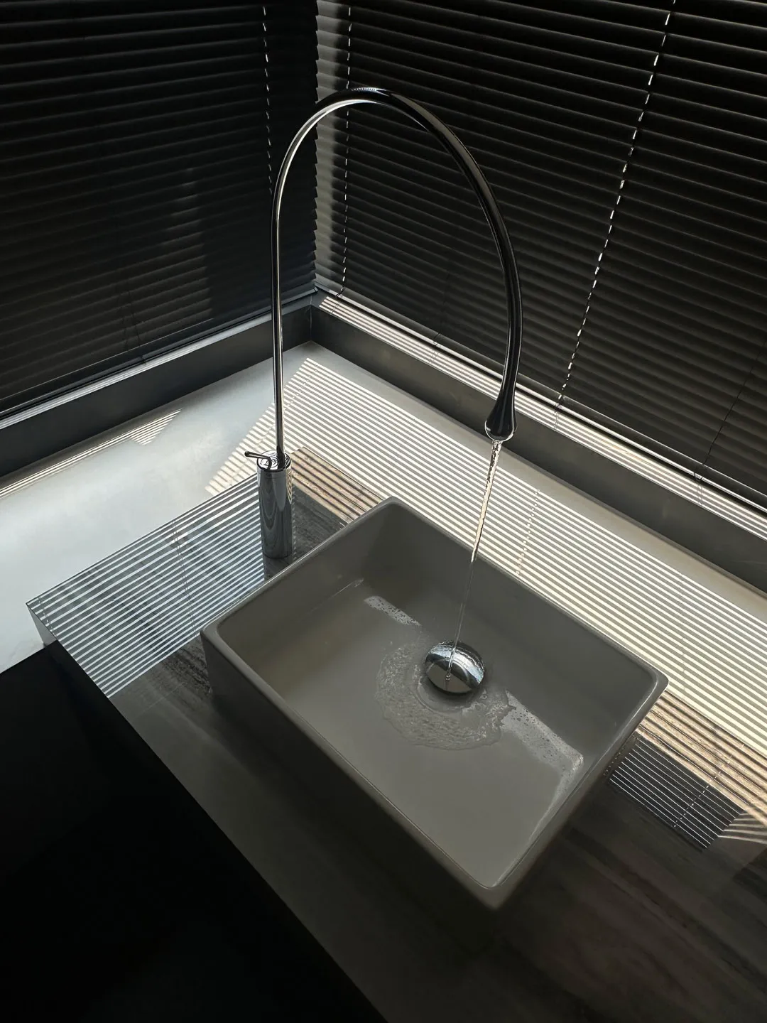 A sleek, minimalist bathroom sink with a ceramic basin and a modern faucet.