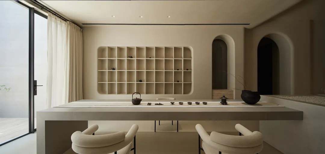 現代餐廳融合混凝土與木質元素,長桌搭配簡約餐具,並有拱形門框