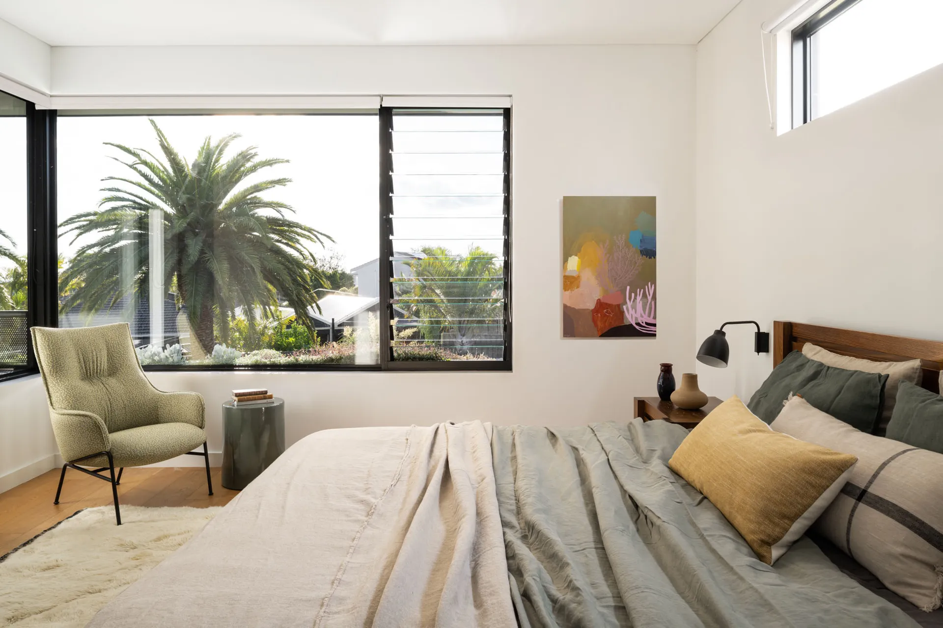 A minimalist bedroom featuring wood, fabric, and metal elements.