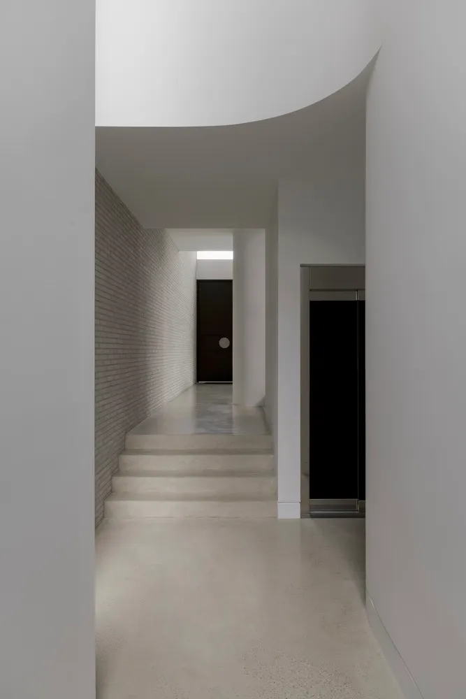 Modern hallway with concrete and brick walls and floors.