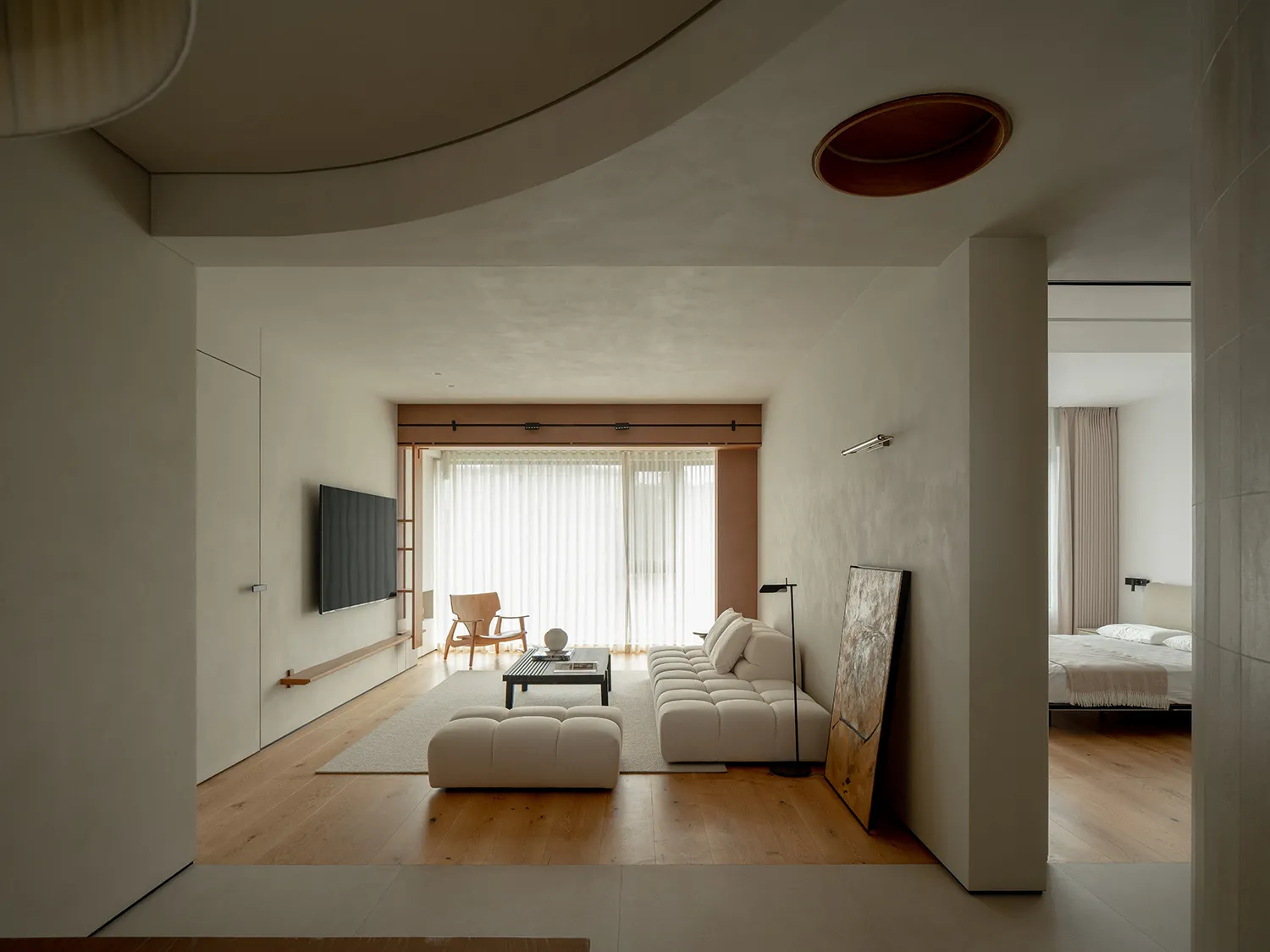 Modern living room with minimalist design, neutral tones, and a combination of light wood, white, and beige elements.