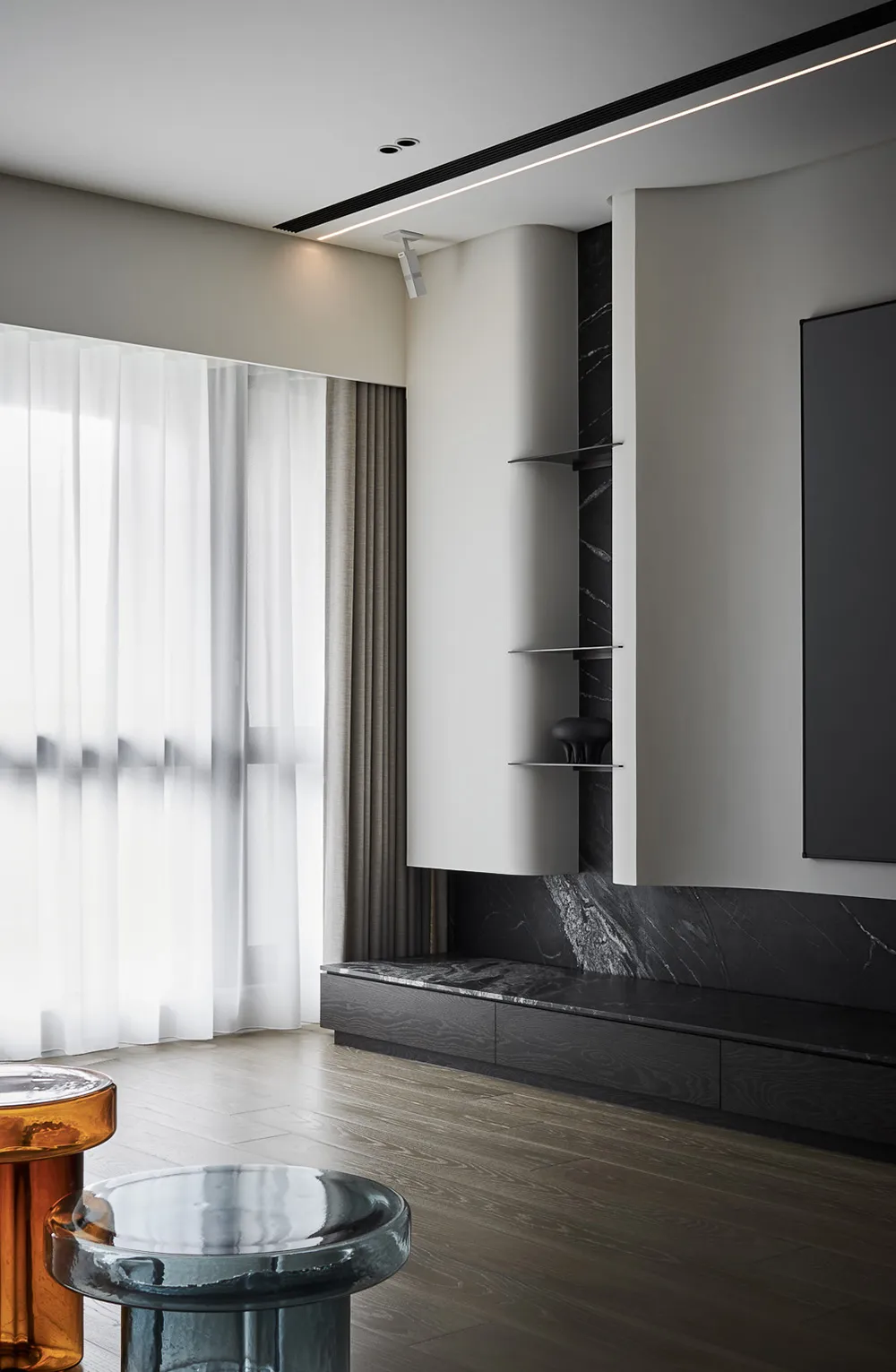 Modern living room featuring a sleek, minimalist design with marble cabinetry and glass stools.