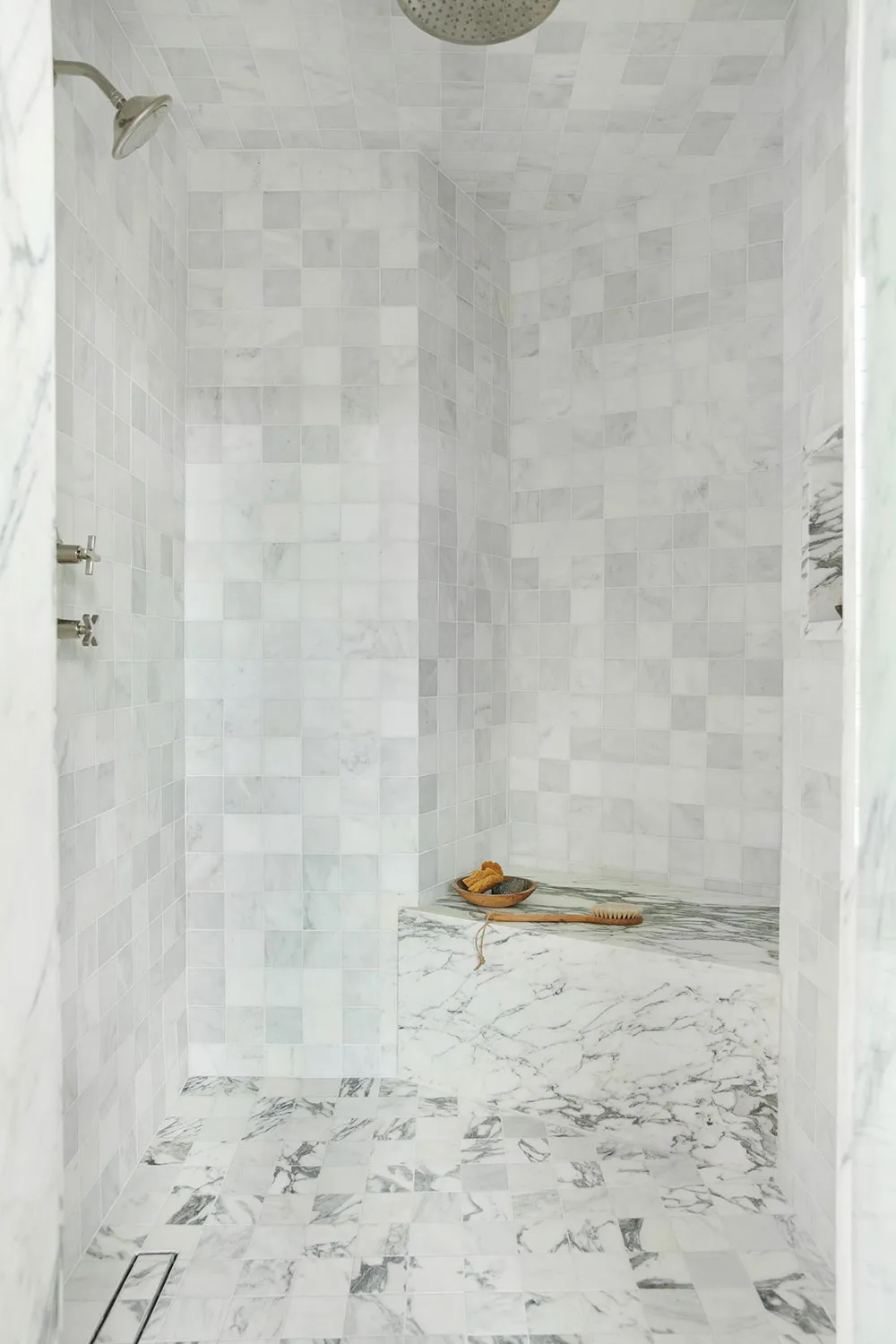 A modern minimalist marble bathroom with marble tiles on the walls and floor.