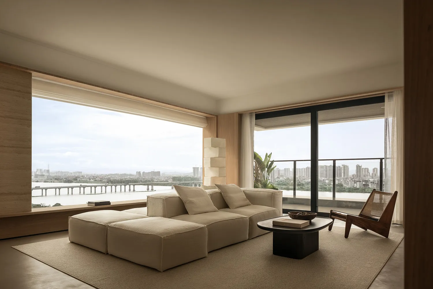 A contemporary living room with minimalist furniture, neutral color palette, and a stunning view of a cityscape.