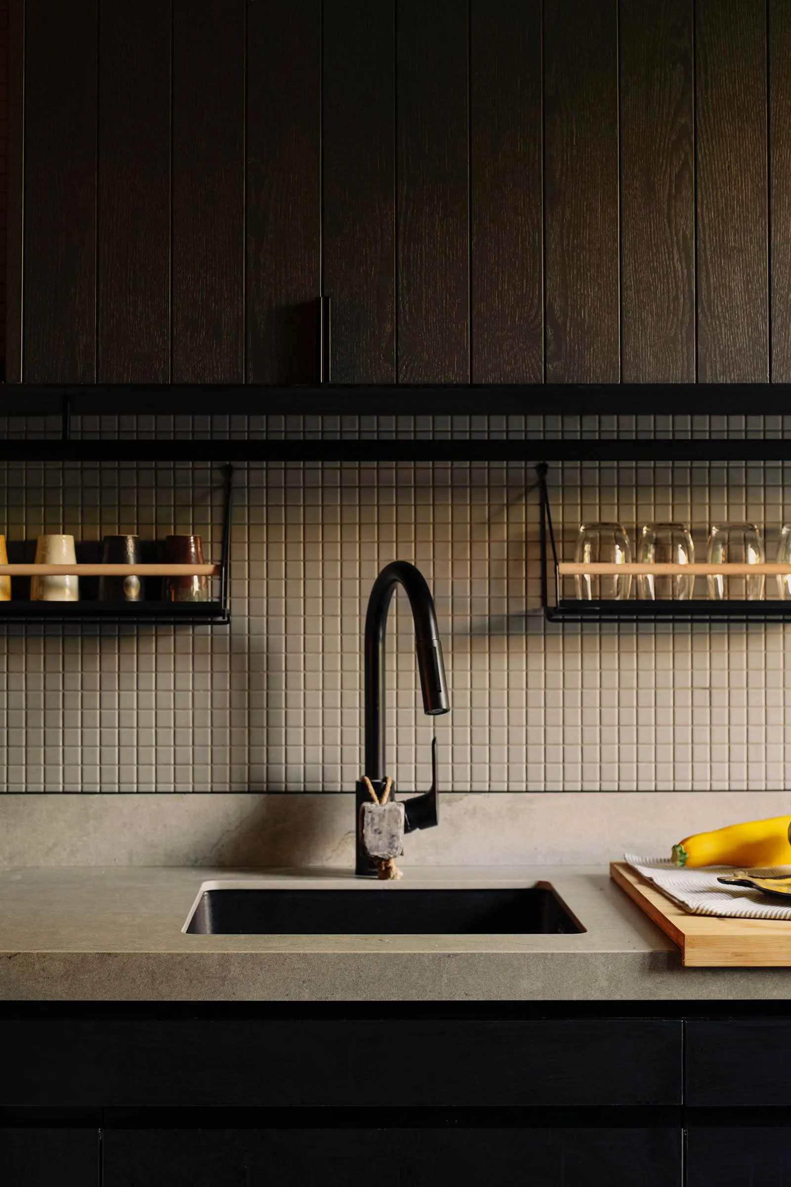 A modern kitchen with concrete tiles and wood paneling