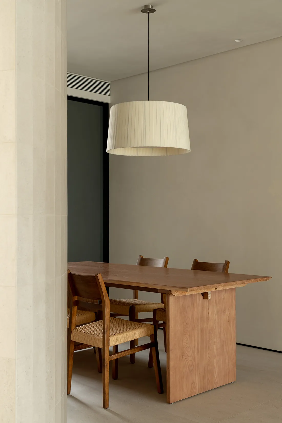 Minimalist dining room featuring a wooden table with fabric chairs.