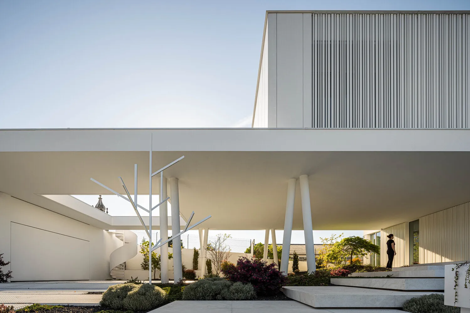 A minimalist, modern building with concrete elements and a playground.