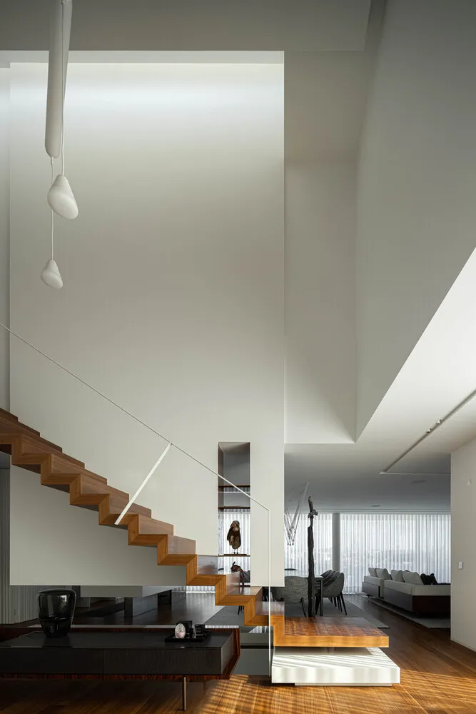 Modern interior with wooden staircase and concrete living room