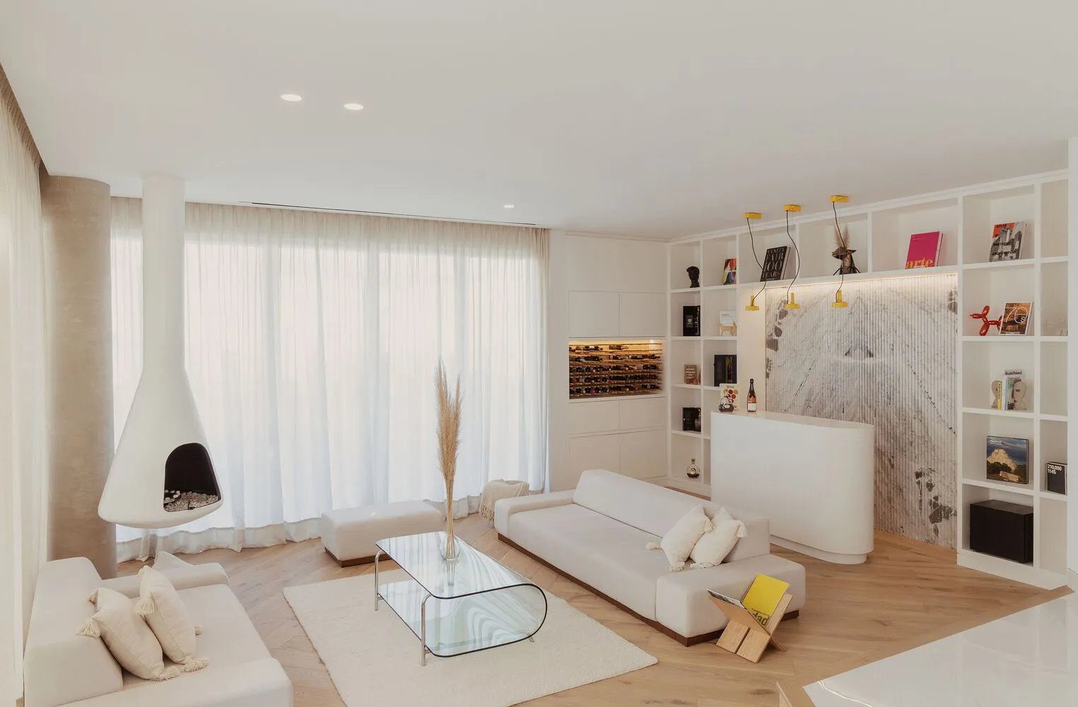 A modern white living room with wooden floors, glass coffee table, and marble accents.