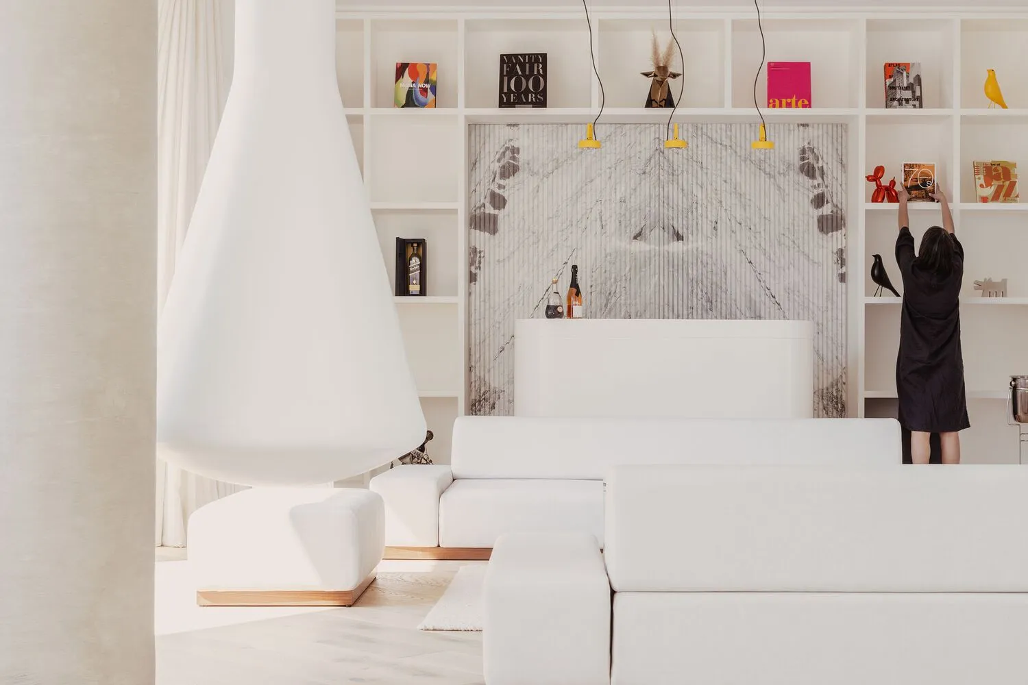 A modern living room with white furniture and a white wall