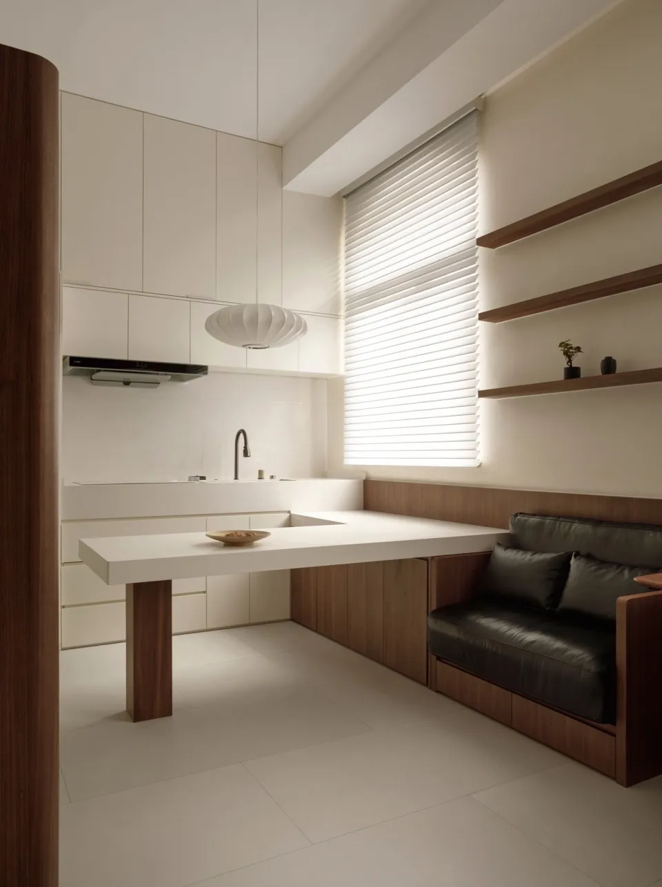 A modern minimalist kitchen with a white marble countertop, white cabinets, and a window with blinds.
