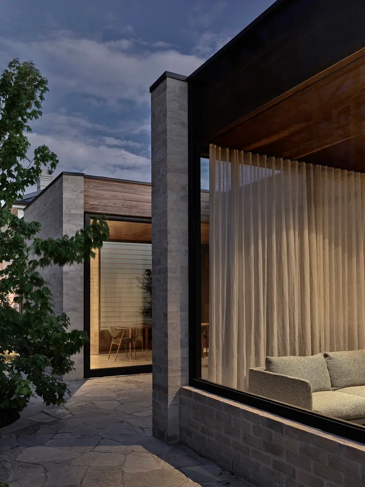 A modern exterior with stone walls and curtains.