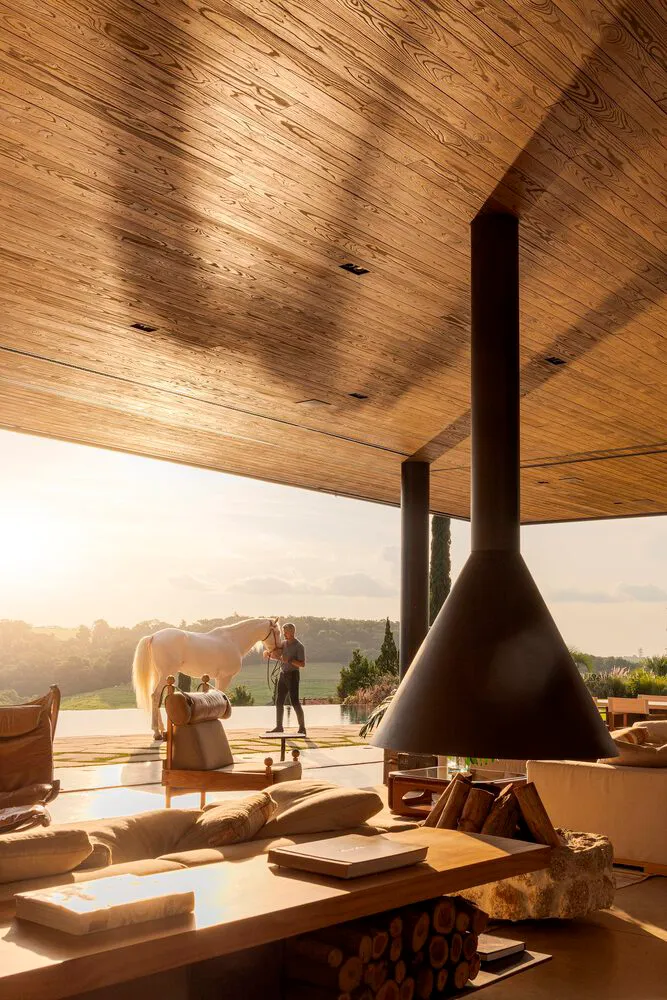 Modern living room featuring wood, concrete, and metal materials with a view of the outdoors.