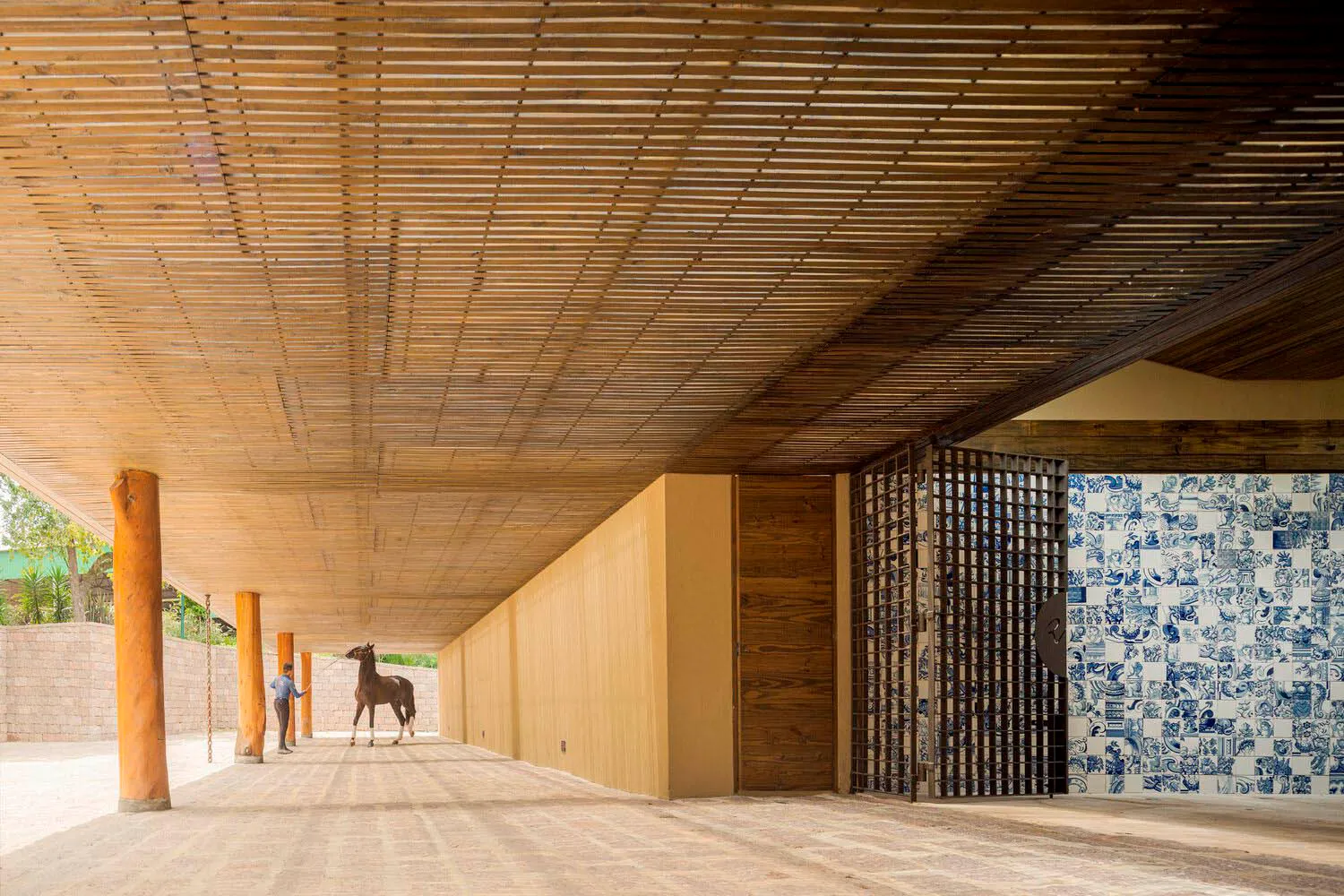 Modern architectural interior space made from wood with blue and white tiled wall and a horse model.