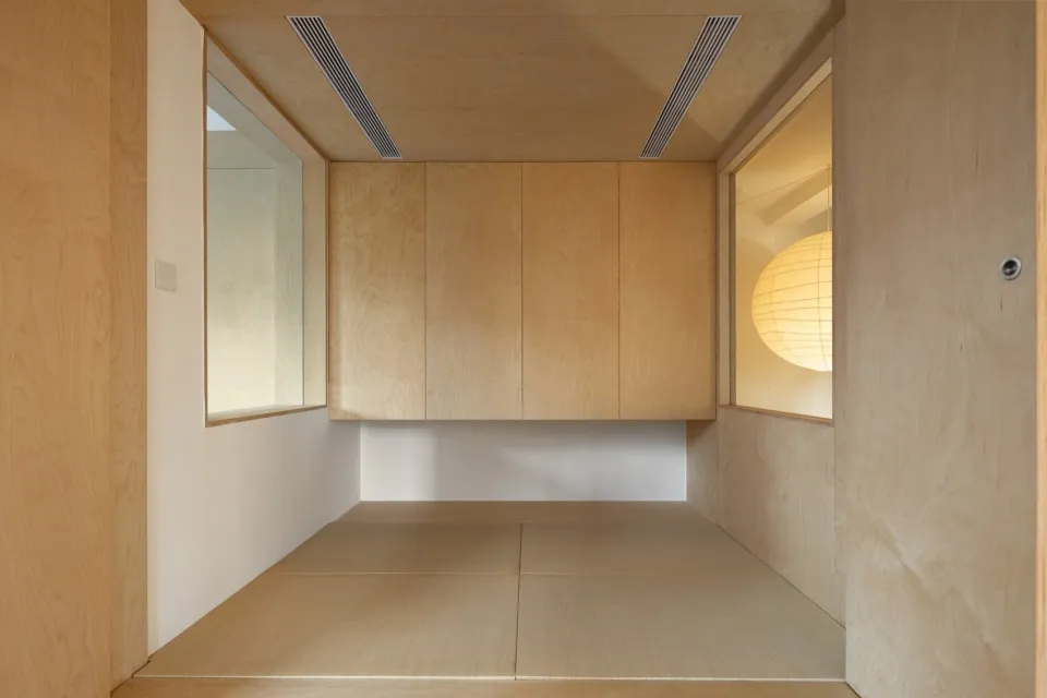 A minimalist room with wooden panels and a light globe
