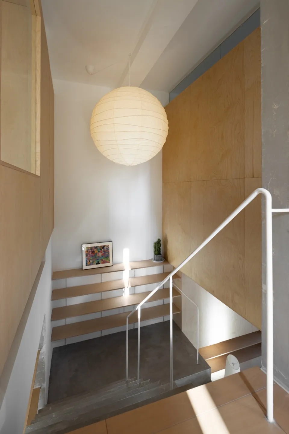 A modern staircase with wooden steps and railings.