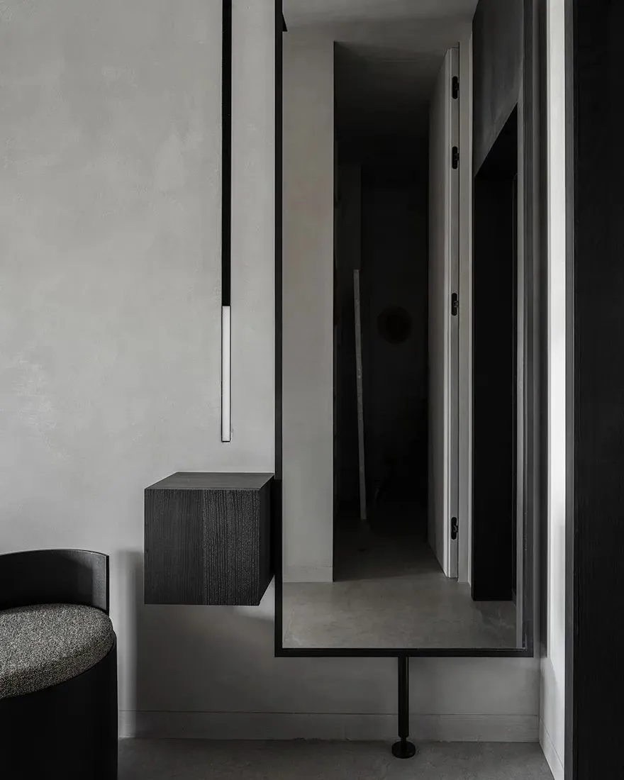 Modern interior with concrete walls, floor, and floating cabinet.